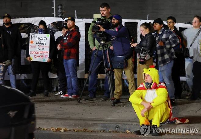 성조기 망토를 두른 닭 의상으로 시위에 참여한 시민.연합뉴스