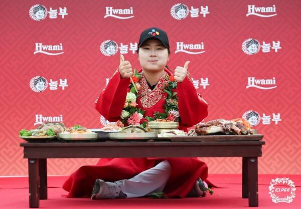 홍정민이 12일 열린 한국여자프로골프(KLPGA) 투어 K-푸드놀부·화미 마스터즈에서 우승한 뒤 한식상 앞에서 기뻐하고 있다. KLPGA 제공