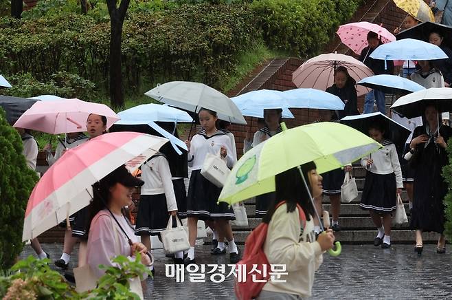 가을비가 내린 서울 중구 명동에서 시민들이 내리는 비를 피해 우산을 쓰고 있다. [한주형기자]