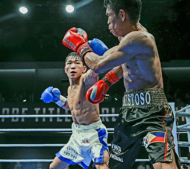 도전자 김우현이 2025년 10월 서울특별시 섬유센터 이벤트홀 사단법인 한국복싱커미션 KBM 밴텀급 타이틀매치에서 챔피언 조버 아미스토소를 때리고 있다. 김우현은 세계복싱협회 슈퍼플라이급 아시아 챔피언을 지냈다. 사진=FINAL FLASH 제공