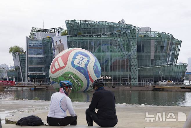 [서울=뉴시스] 김근수 기자 = 12일 서울 서초구 한강시민공원 세빛둥둥섬에 2026년 국제축구연맹(FIFA) 북중미 월드컵의 공인구 '트리온다'(TRIONDA)가 설치돼 있다. 아디다스는 트리온다의 국내 공개를 기념해 서울 세빛둥둥섬에서 'SOAP BALL' 이벤트를 개최한다고 밝혔다.2026년 국제축구연맹(FIFA) 북중미 월드컵의 공인구 '트리온다'(TRIONDA)는 세 개'(Tri)'의 '파도'(Onda)라는 뜻의 트리온다는 월드컵 공동 개최국인 캐나다·멕시코·미국을 기념하는 디자인으로 제작됐다. 빨강, 파랑, 초록의 국가 색상이 중앙 삼각형으로 이어져 세 나라가 하나되는 최초의 월드컵을 의미하며, 미국의 별, 캐나다의 단풍잎, 멕시코의 독수리 등 개최국의 대표 아이콘을 굵직한 그래픽과 엠보싱 기법으로 반영했다. 2025.10.12. ks@newsis.com