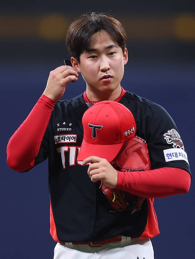 KIA 윤영철이 지난 6월 24일 키움과의 경기 도중 피치컴 장비에서  소리가 들리지 않자 기기를 확인하고 있다. 연합뉴스