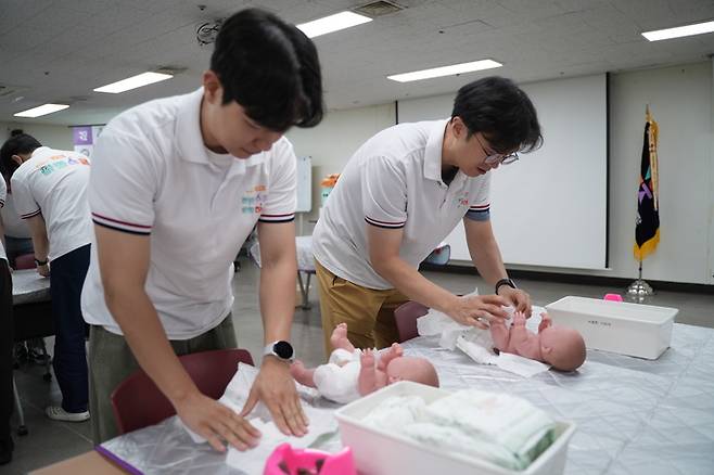지난달 27일 진행된 경기도 아빠스쿨 교육 프로그램 '신생아 돌보기의 기초'에 참여한 남성양육자들이 기저귀 갈기 실습을 하고 있는 모습. 사진=경기도여성가족재단
