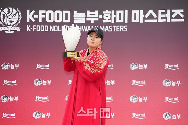 홍정민이 12일 경기도 용인시 88컨트리클럽에서 열린 KLPGA 투어 K푸드 놀부 화미 마스터즈 초대 챔피언으로 시즌 3승 고지에 올랐다. 홍정민이 우승자에게 수여하는 두루마기를 입고 트로피를 들어 올리고 있다. (사진=이데일리 골프in 조원범 기자)