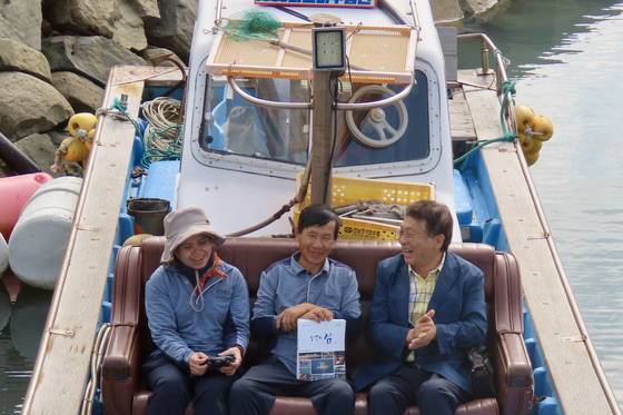 이재언 연구원(오른쪽)이 전남 여수시 백야도에서 윤근조·마이나 집배원 부부에게 본인 저서인 『한국의 섬』을 선물하고 있다. 김홍준 기자