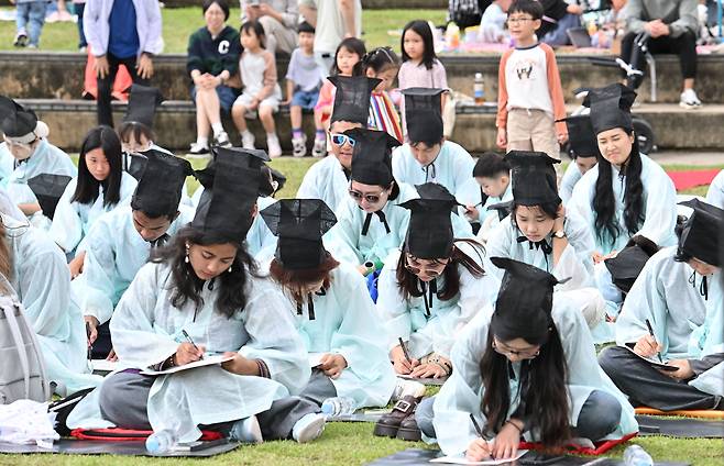 9일 오전 세종시 세종호수공원 매화공연장에서 열린 제2회 세종한글대전에서 외국인 및 가족동반 참가자들이 한글문제를 풀고 있다. 세종=임세준 기자