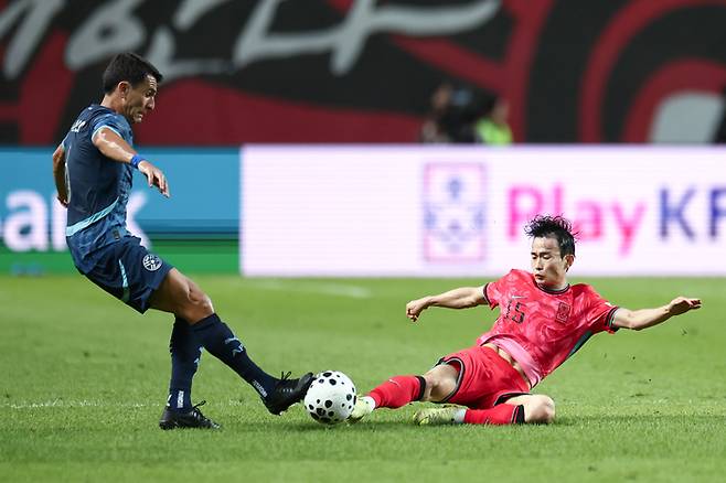 김문환(오른쪽)이 파라과이전에서 태클을 시도하고 있다. 사진 | 연합뉴스