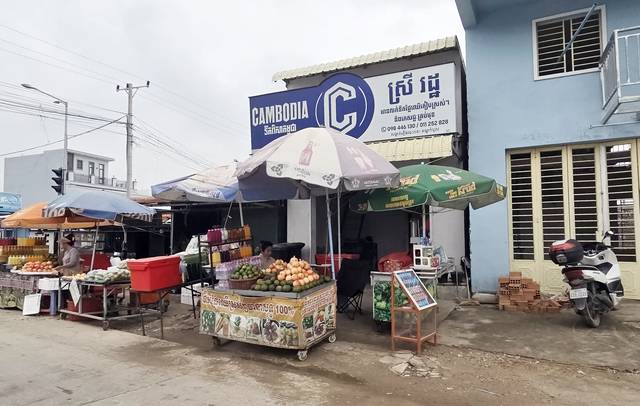 14일(현지시간) 오후 캄보디아 수도 프놈펜 인근 노점상에서 상인이 과일을 팔고 있다. 연합뉴스