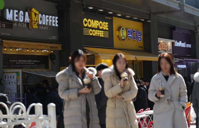 ▲ 저가 커피 판매점이 밀집한 서울 종로구의 한 상가 앞으로 시민들이 걸어가고 있다. 연합뉴스 자료사진.