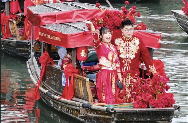 지난 9월 중국 동부 장쑤성 쑤저우 루즈 고대 마을에서 열린 단체 결혼식에서 커플이 보트 투어를 즐기고 있다. 신화연합뉴스