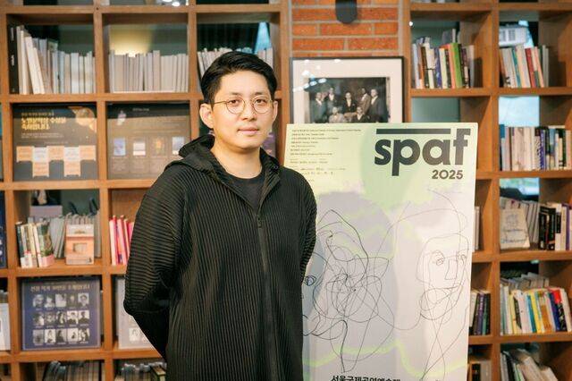 서울국제공연예술제(SPAF)의 협력예술가인 구자하가 13일 서울 종로구 예술가의집에서 포스터를 배경으로 포즈를 취하고 있다. 서울국제공연예술제 제공
