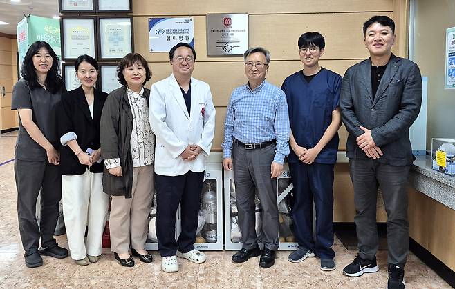 울릉군 보건의료원과 칠곡경북대학교병원이 도서 지역 응급의료 체계를 강화하기 위해 울릉군 보건의료원에 업무협약  현판식 개최후 단체 기념사진을 찍고 있다[울릉군 보건의료원 제공]