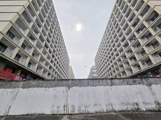 3m 넘는 담벼락 - 14일(현지시간) 오후 캄보디아 시하누크빌에 있는 범죄 단지로 추정되는 건물 인근에 3m가 넘는 담벼락이 서 있다. 2025.10.14 연합뉴스