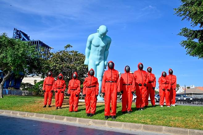 '그리팅맨' 제막식에 등장한 '오징어게임' (라스팔마스=연합뉴스) 14일(현지시간) 스페인령 카나리아 제도 라스팔마스의 라루스항에서 한·스페인 수교 75주년을 기념해 한인 어부들의 노고를 기리는 조각상 '그리팅맨' 제막식이 열린 가운데 '오징어게임' 복장을 한 한류 팬들이 기념 촬영을 하고 있다. 2025.10.14 [주스페인 대사관 라스팔마스 분관 제공]