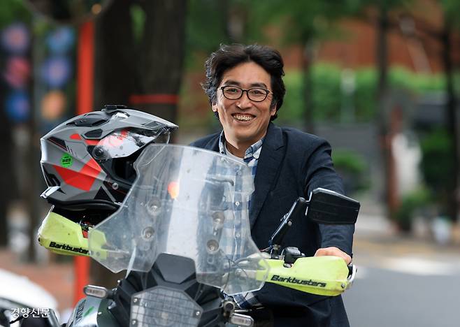 새만금국제공항 기본계획 취소소송 1심에서 승소 판결을 이끌어낸 최재흥 변호사가 지난 1일 서울 정동길에서 타고 온 오토바이를 주차하며 환하게 웃고 있다. 그는 이 오토바이를 타고 전국의 환경 분쟁 현장을 다니고 있다. 서성일 선임기자