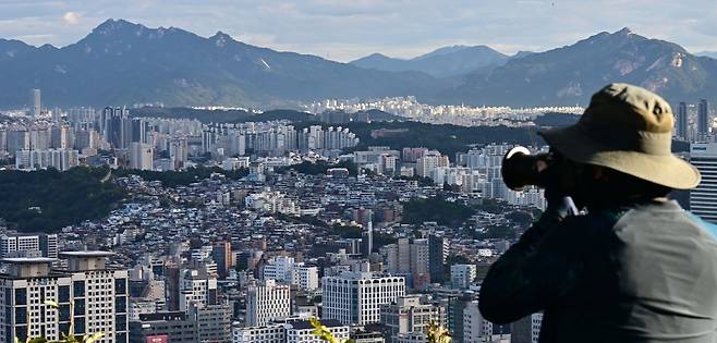 서울 전역 및 경기 12개 지역을  규제지역 지정하고 LTV 40%로 축소하는 10.15 부동산 대책이 발표된 가운데 15일 오전 서울 남산에서 한 시민이 서울 시내 아파트를 바라보고 있다.  이상섭 기자