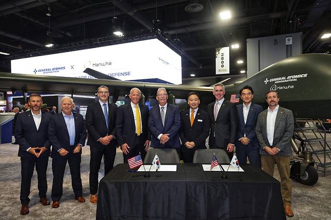 한화에어로스페이스가 미국 '제너럴 아토믹스 에어로노티컬 시스템(GA-ASI)'과 손잡고 무인기 사업 진출을 본격화한다. 김선 한화에어로스페이스 항공사업부장(오른쪽 네번째)과 데이비드 알렉산더 제너럴 아토믹스 에어로노티컬 시스템 사장(오른쪽 다섯번째)이 14일(현지시간) 미국 워싱턴DC에서 열린 미 육군협회(AUSA) 방산 전시회에서 GA-ASI와 단거리 이착륙(STOL) 무인기 '그레이 이글(Gray Eagle·GE)-STOL'의 공동개발 계약을 체결한 뒤 기념촬영하고 있다. 한화에어로 제공