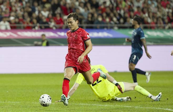 축구대표팀 오현규가 14일 서울월드컵경기장에서 열린 파라과이 평가전에서 후반 30분 단독 찬스에서 상대 골키퍼를 제치며 추가골을 터트리고 있다.  상암｜뉴시스