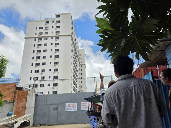 16일 한 캄보디아 주민이 수도 프놈펜 외곽 센속 지역 ‘사쿠라 단지’에 있는 웬치를 올려다보고 있다. 프놈펜=이영근 기자