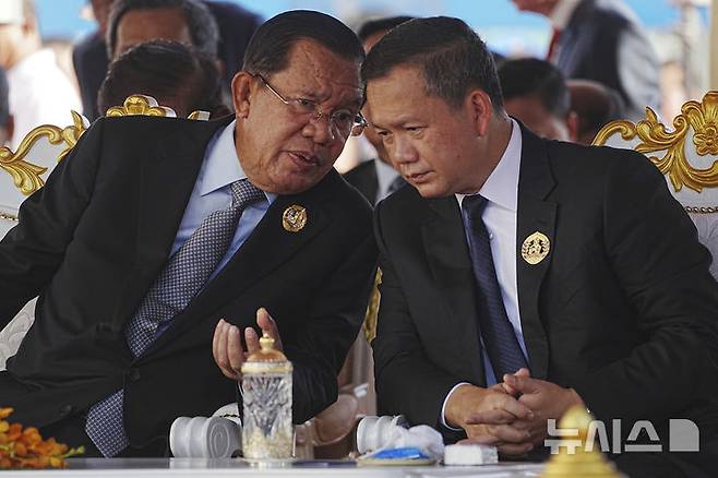 [프놈펜=AP/뉴시스] 캄보디아 실권자인 훈센 상원의장(왼쪽)과 아들 훈마넷이 올해 6월28일 수도 프놈펜에서 열린 행사에서 대화를 나누고 있다. 2025.08.06
