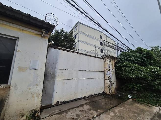 지난 14일 캄보디아 프놈펜 주변 주요 범죄 단지인 원구 단지에 벽과 철조망이 설치돼 있다. 5층 건물 4개 동으로 이뤄진 원구 단지에는 피싱 범죄 조직이 자리잡고 한국인을 대상으로 한 감금, 강제 노동 등이 이뤄졌던 것으로 알려졌다. 캄보디아에서는 범죄 단지 형태 외에 대형 호텔이나 콘도 등의 공실을 임차해 범죄 공간으로 삼는 경우도 많다. 정인선 기자