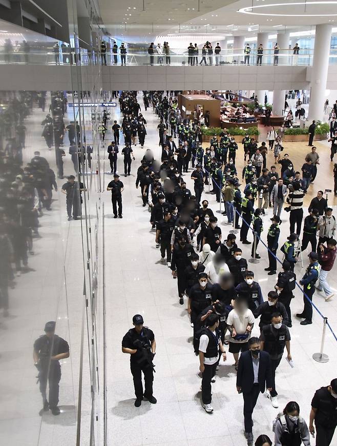 캄보디아 온라인 사기에 가담해 구금된 한국인들이 18일 오전 인천국제공항 제2터미널을 통해 송환되고 있다. 이날 송환에는 경찰 호송조 190여명이 투입됐다. 사진공동취재단