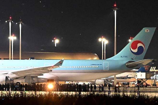 2025년 10월 18일 캄보디아 캔달주 테초국제공항에서 한국 경찰 관계자들이 송환용 전세기 인근에 서 있다. 캄보디아 당국은 온라인 사기 단속 과정에서 구금된 한국인 60여 명을 이날 새벽 한국으로 송환했다. AFP 연합뉴스