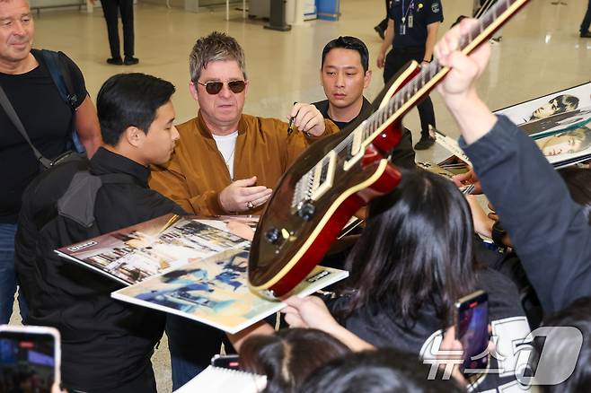 16년 만의 내한 공연을 앞둔 밴드 오아시스(Oasis)의 노엘 갤러거(Noel Gallagher)가 19일 오후 인천국제공항 2터미널을 통해 입국하며 팬들에게 사인을 해주고 있다. 2025.10.19/뉴스1 ⓒ News1 안은나 기자