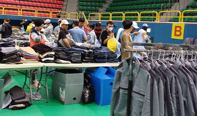 전남 진도실내체육관에서 19일 진행된 ‘이주노동자 작업복·겨울옷 나눔행사’를 찾은 외국인 노동자들이 옷을 고르고 있다. 전남노동권익센터 제공