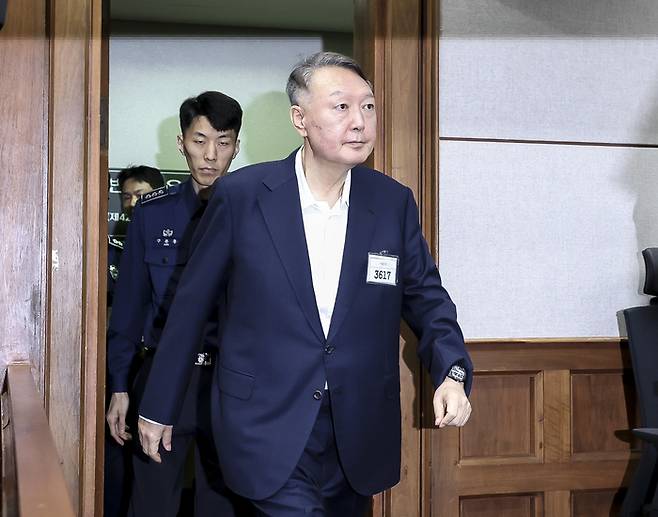 윤석열 전 대통령이 지난달 26일 서울중앙지법에서 열린 특수공무집행방해, 직권남용 권리행사방해 등 혐의 사건 첫 공판에 출석하고 있다. 형사 법정에서 윤 전 대통령의 모습이 공개된 것은 지난 4월 내란 사건 재판 이후 약 5개월 만이다. [사진 = 뉴스1]