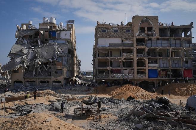 하마스 대원들이 10월 19일(현지시간) 가자지구 남부 칸유니스의 파괴된 건물 잔해 속에서 이스라엘 인질의 시신을 수색하고 있다. AP 연합뉴스