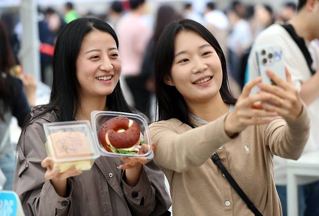 18일 대전에서 열린 빵축제를 찾은 관광객이 구매한 빵을 들고 기념사진을 찍고 있다. /신현종 기자