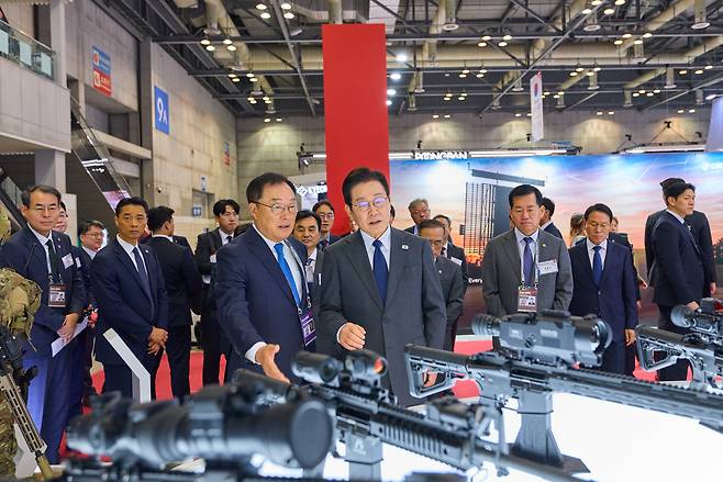 President Lee Jae Myung (right, front) visits an exhibition booth at the Seoul ADEX 2025 in Goyang, Gyeonggi Province, on Monday. (Presidential office)