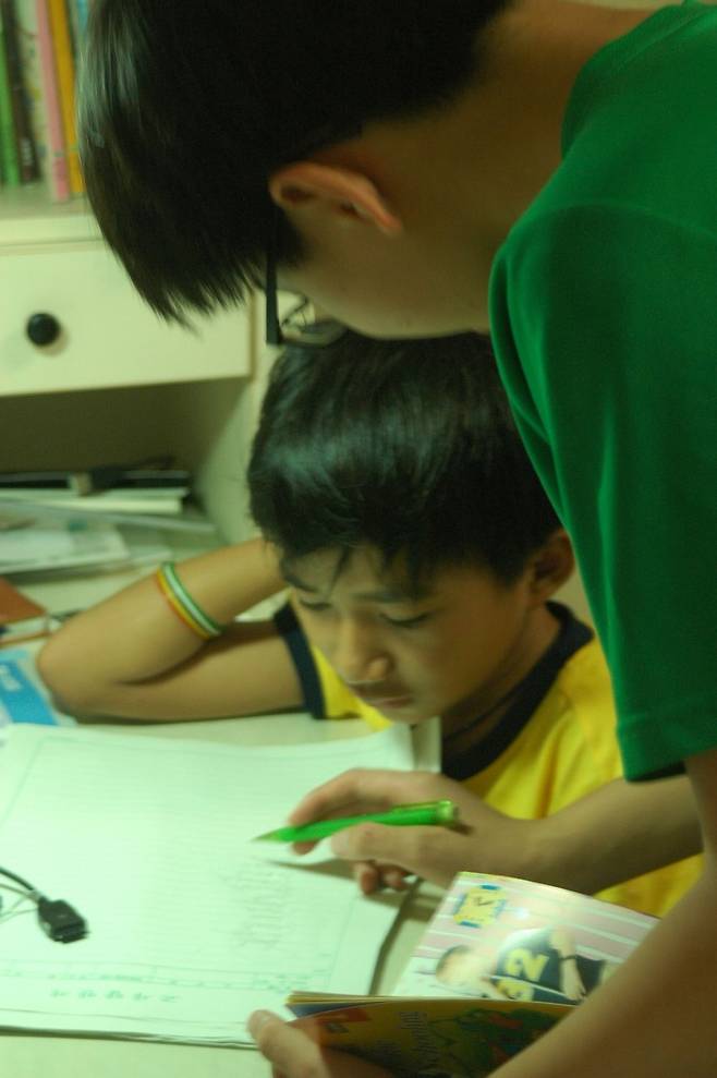 김재원 아나운서가 10여년 전 캄보디아 소년을 집으로 데려와 한 달을 보냈을 당시 모습. 중학생 아들이 소년과 함께 공부하는 모습. 김 아나운서 제공