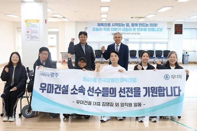 김영길 대표(뒷줄 오른쪽)가 ‘제45회 전국장애인체전’에 출전하는 우미건설 소속 장애인체육 선수들과 기념사진을 찍고 있다. [사진 = 우미건설]