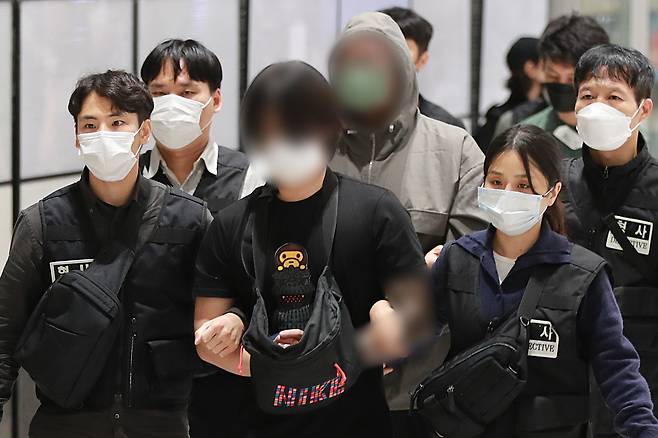 캄보디아 온라인 사기에 가담해 구금된 한국인들이 18일 오전 인천국제공항 제2터미널을 통해 송환되고 있다. 이날 송환에는 경찰 호송조 190여명이 투입됐다. [연합]