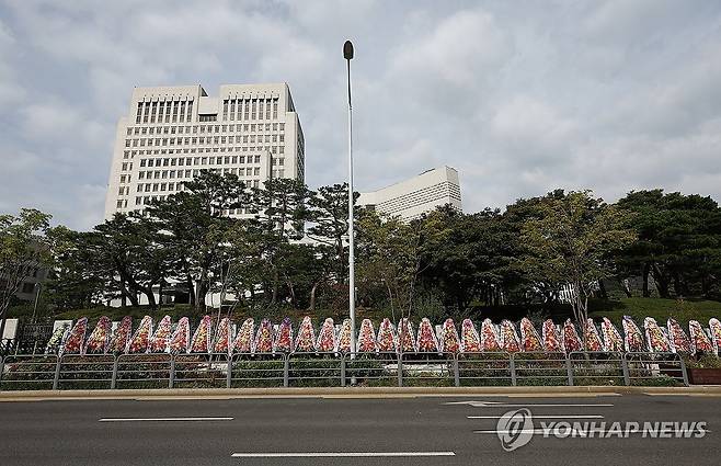 대법관 증원 개혁안 발표…대법원 앞에 놓인 화환들 (서울=연합뉴스) 김성민 기자 = 더불어민주당 사법개혁특별위원회가 20일 현행 14명인 대법관을 26명으로 증원하는 사법개혁안을 발표했다. 
    이날 서울 서초구 대법원 앞에 화환이 놓여 있다. 2025.10.20 ksm7976@yna.co.kr
