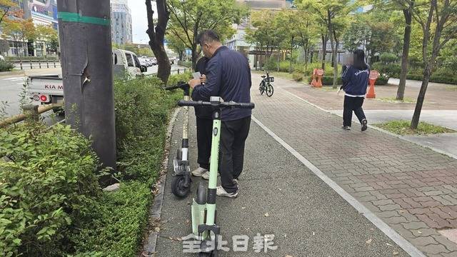 전주시 공무원들이 무단 방치된 킥보드에 계고장을 부착하고 있다. /김문경 기자