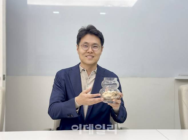박상원 천일에너지 대표가 폐목재를 재활용한 우드칩을 들고 있다.(사진=천일에너지)