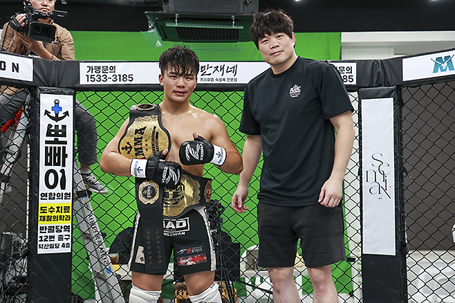 KMMA 슈퍼라이트급 챔피언에 이어 라이트급 잠정 챔피언이 된 이현우에게 KMMA 김대환 대표이사가 시상하고 있다. 사진=스탠다드앤드프로그레스 스포츠에이전시