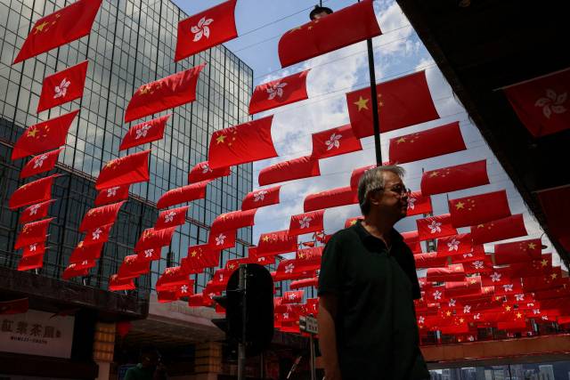 10월 1일 중국 홍콩에서 열린 제76회 국경일에 한 남성이 중국 국기와 홍콩 국기가 그려진 쇼핑몰 근처를 걷고 있다. 로이터연합