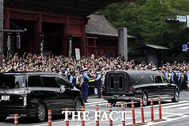 지난 2022년 7월 아베 신조 전 일본 전 총리를 사제 총기로 살해한 혐의를 받는 야마가미 데쓰야의 모친이 아들의 재판에 증인으로 출석할 예정으로 알려졌다. 사진은 지난 2022년 7월 12일 아베 전 총리의 시신 운구 차량(오른쪽)이 일본 도쿄의 조죠지에서 장례식을 마친 사찰을 떠나는 모습. /AP.뉴시스
