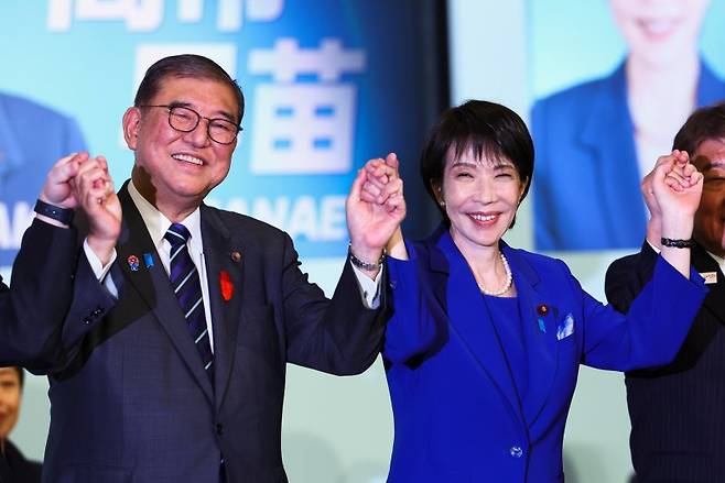 일본 첫 총리로 21일 취임한 다카이치 사나에 일본 전 경제안보담당상이 앞서 지난 4일 일본 도쿄 자유민주당 당사에서 열린 자유민주당 총재 선거에서 당선된 뒤 이시바 시게루 당시 총리와 기념촬영 하고 있다. AP 뉴시스