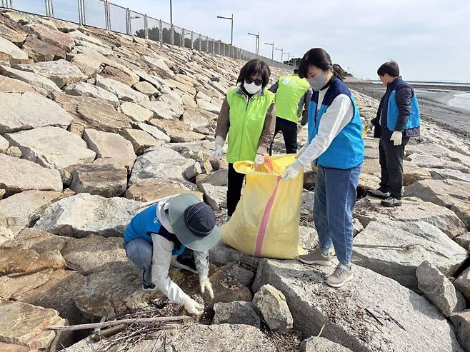 봉사자들이 21일 인천 중구 마시안 해변가에서 쓰레기를 줍고 있다.