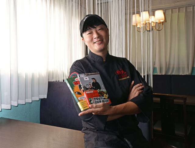 조광효 셰프가 22일 서울 송파구에 위치한 중식당 ‘조광201’에서 최근 펴낸 요리책을 들고 포즈를 취하고 있다. 성형주 기자
