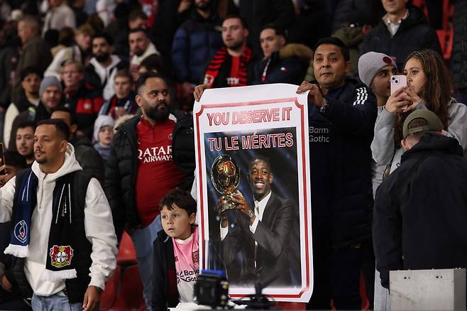 한 축구 팬이 22일 유럽챔피언스리그 PSG-레버쿠젠전에서 뎀벨레의 발롱도르 수상을 축하하는 플래카드를 들어보이고 있다. AFP연합뉴스