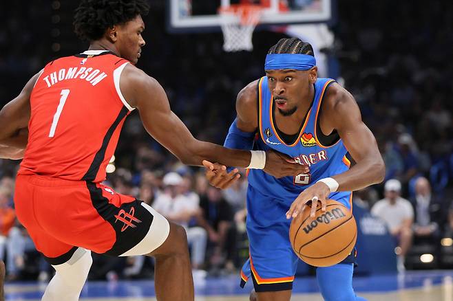 샤이 길저스-알렉산더(오른쪽)가 22일 미국 오클라호마주 오클라호마시티 페이컴 센터에서 열린 휴스턴과 2025~2026 미국프로농구 정규리그 개막전에서 돌파를 시도하고 있다.   오클라호마시티 | AP연합뉴스
