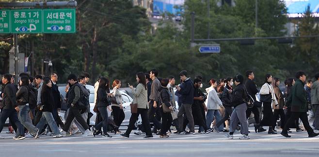 쌀쌀한 아침 날씨가 이어진 지난 22일 서울 광화문광장에서 시민들이 두꺼운 옷차림을 한 채 걸어가고 있다. /연합뉴스