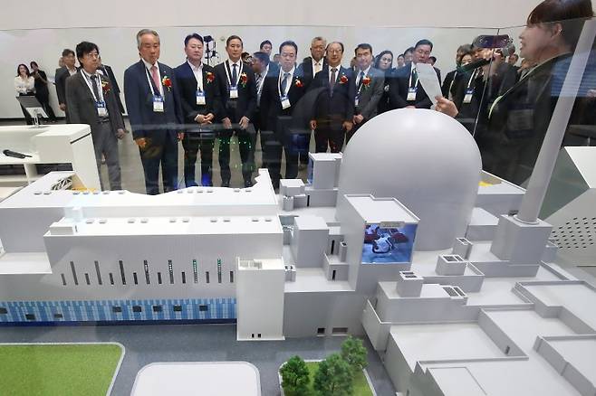 6월 11일 대구 북구 엑스코(EXCO)에서 개막한 '2025 대한민국 전기산업 엑스포'를 찾은 내빈들이 한국수력원자력 부스에 전시된 1000㎿(메가와트)급 한국형 원전 APR1000 발전소의 핵심 구조를 표현한 모형을 살펴보며 관계자 설명을 듣고 있다. 뉴스1