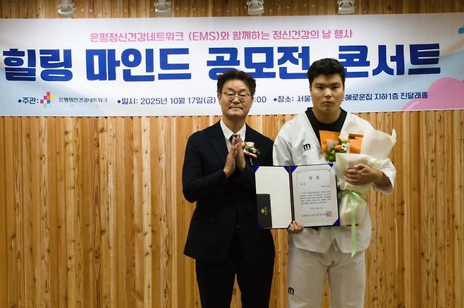 지난 17일 서울 은평구 서울시립은혜로운집에서 열린 ‘힐링 마인드 공모전, 콘서트’에서 수기 대상을 받은 오순민씨가 수상 후 기념 촬영을 하고 있다.